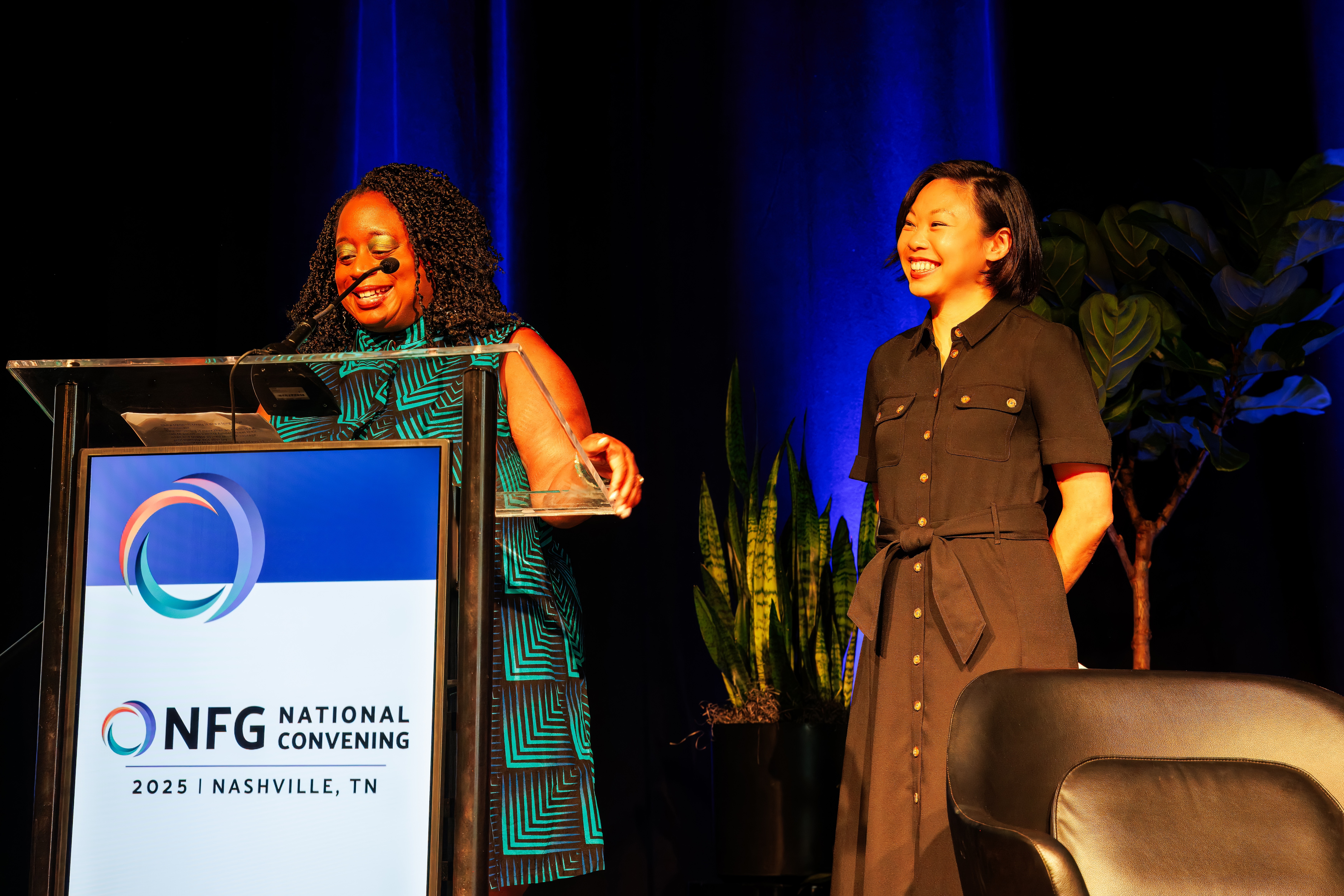 Amanda Andere speaks at podium next to Stephanie Chan at NFG's 2025 National Convenig.